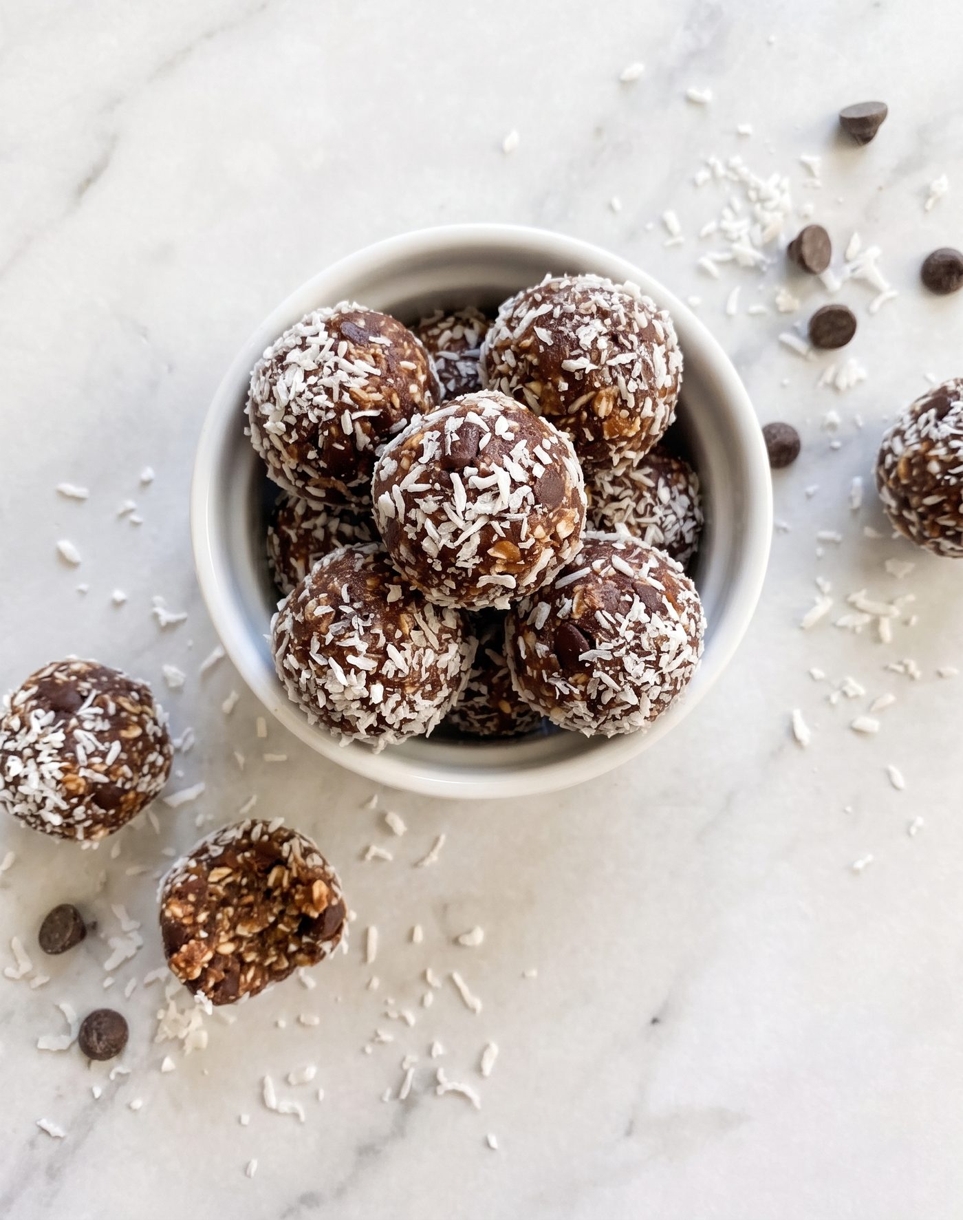 No-bake coconut energy bites rolled in shredded coconut, piled in a small bowl